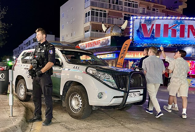 Pictured: Officers patrol the strip as partygoers walk around behind them