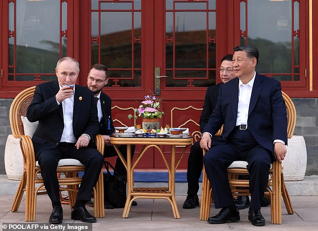In this photo, distributed by the Russian state agency Sputnik, Russian President Vladimir Putin and Chinese President Xi Jinping hold an informal meeting at the Zhongnanhai leadership complex in Beijing on May 16, 2024.