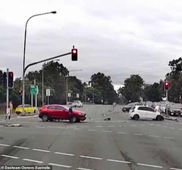 The driver crashes into a white Toyota hatchback, which does a 360-degree spin before hitting a red Mazda SUV in the adjacent lane (pictured)