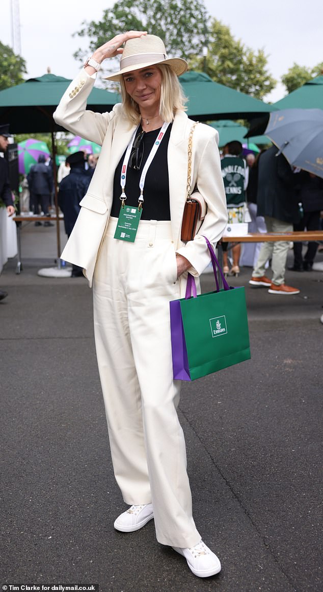 Wimbledon regular Jodie Kidd looked chic in cream and stayed dry under a fedora hat