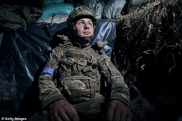 A soldier rests as infantry secures the area for the 3rd Assault Brigade at sunset on July 1, 2024 in the Kharkiv region