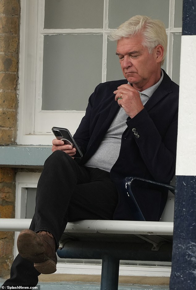 The former This Morning presenter, 62, took a puff on an e-cigarette while checking his phone as he waited for the train