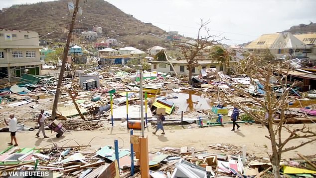 People walk among damaged properties after Hurricane Beryl passed through Union Island, Saint Vincent and the Grenadines