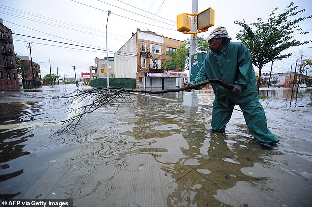 New York City is one of the largest metropolitan areas at risk of sewage flooding because its pipes, built in the mid-1850s, were unable to handle rainfall of more than 1.75 inches per hour. Pictured: Man tries to unclog a sewer grate after Hurricane Irene hit Coney Island in 2011