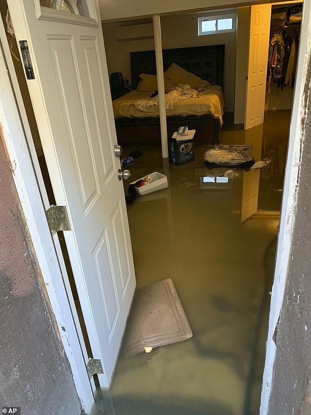 In 2019, sewage flooded into about 300 homes in Jamaica, Queens, destroying furniture, electronics and other belongings as the stinking waste spread through the area. Pictured: Sewage filling Cynthia McKenzie's home in Jamaica Queens in November 2019