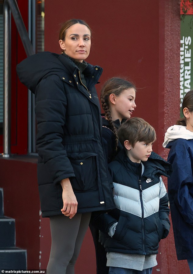 The mother of two, who has eight-year-old daughter Violet and five-year-old son Dominic with her husband Michael Miziner, dressed warmly in a black Aje Athletica coat over a turtleneck.