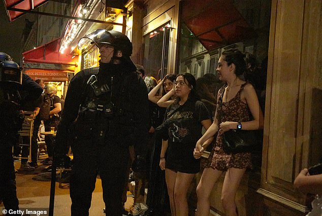 Young women trying to enjoy a night out on the town were forced to stand behind armored police officers