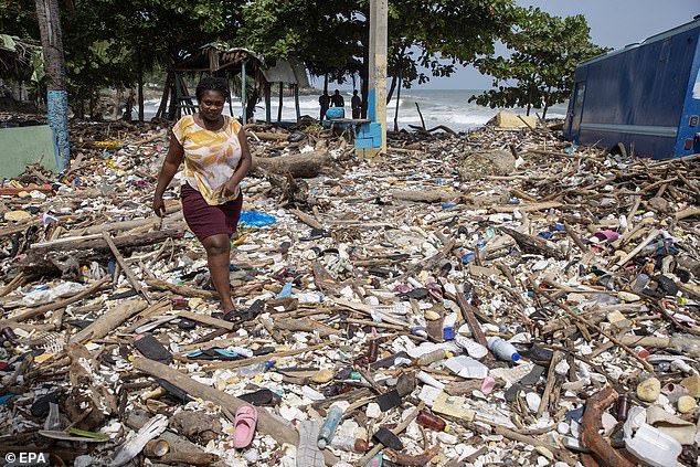 A woman walks along Manresa beach covered in trash after the passage of Hurricane Beryl in Santo Domingo, Dominican Republic, July 3, 2024