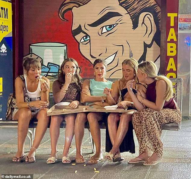 Five tourists share a pizza and chips after leaving a bar in Magaluf