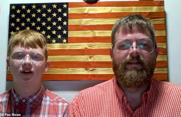 John Beard and his son Jayden didn't have a flagpole tall enough to display the gigantic Old Glory, so they meticulously laid it across their house