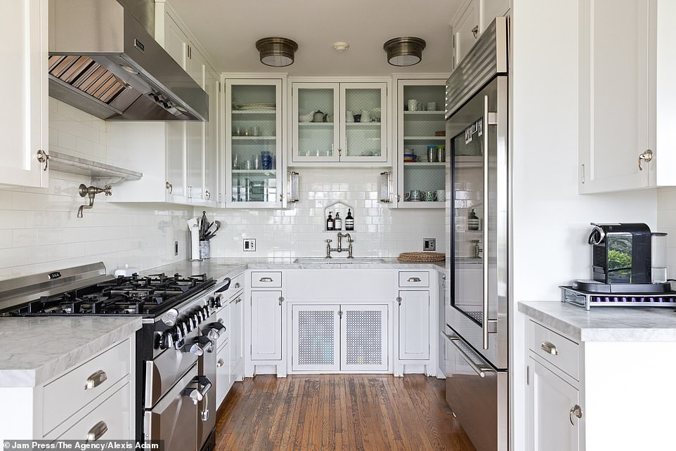 The white tiled kitchen offers plenty of space for cooking and is equipped with the latest appliances.