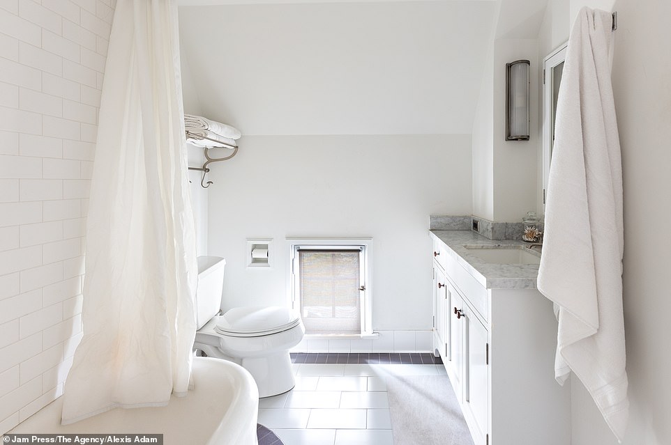 Another bathroom has a unique mini window and a bathtub to relax in