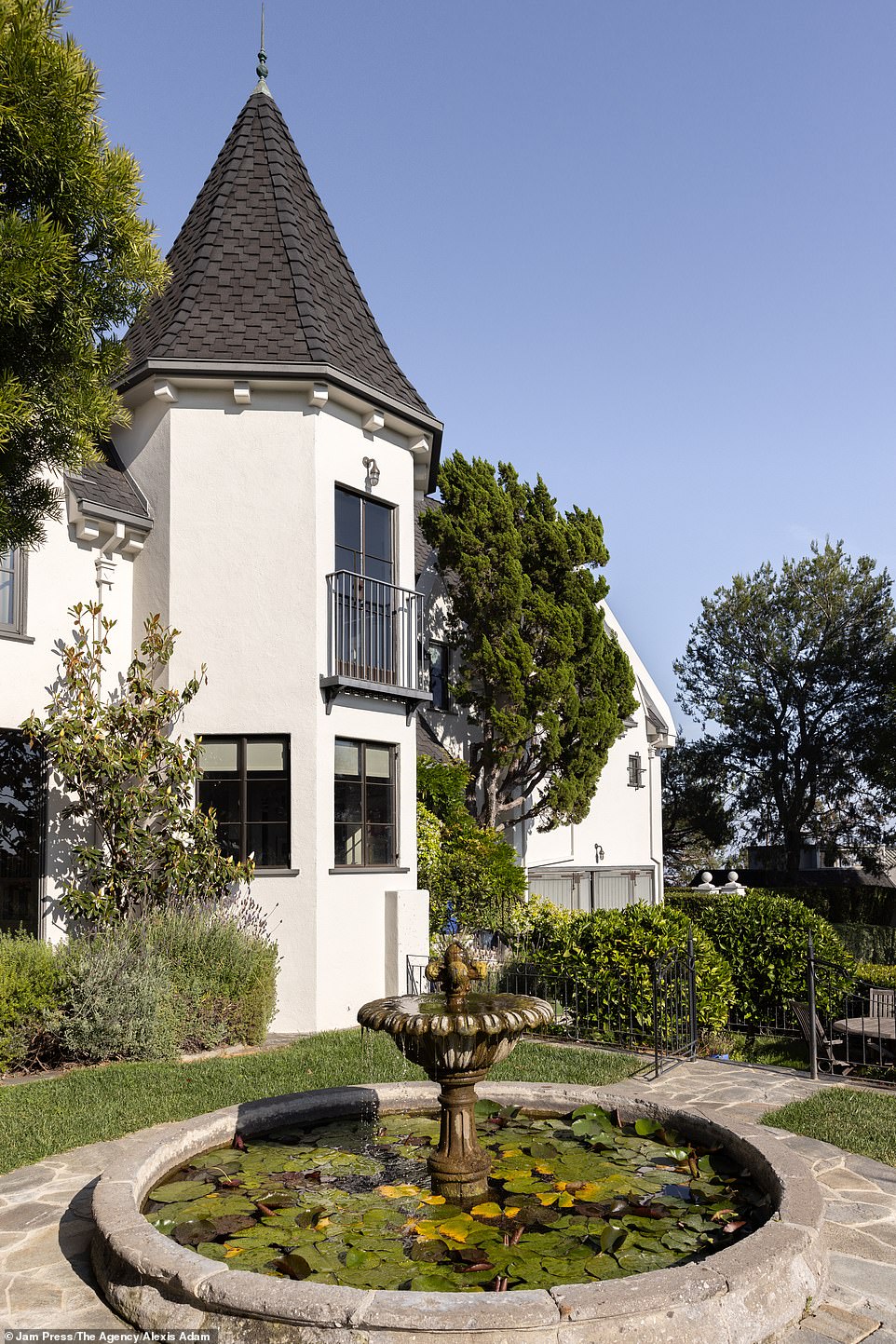 In front of the building is a fountain with floating water lilies everywhere and well-maintained, manicured gardens