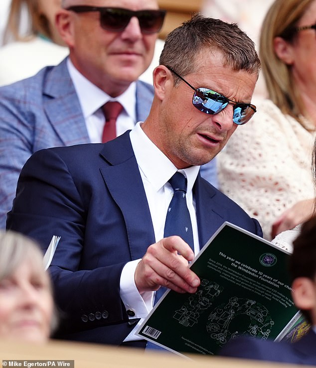 Bear donned a pair of sporty sunglasses as he read the program for the fourth day of the sporting event