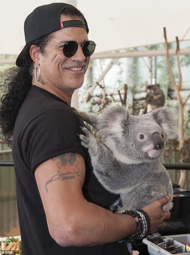 Guns N Roses guitarist Saul Hudson, better known as Slash, holds his first koala at the Lone Pine Koala Sanctuary in Brisbane, Australia, August 22, 2012