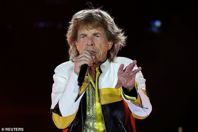 The singer is also seen wearing a yellow, white and black leather jacket over the glittering