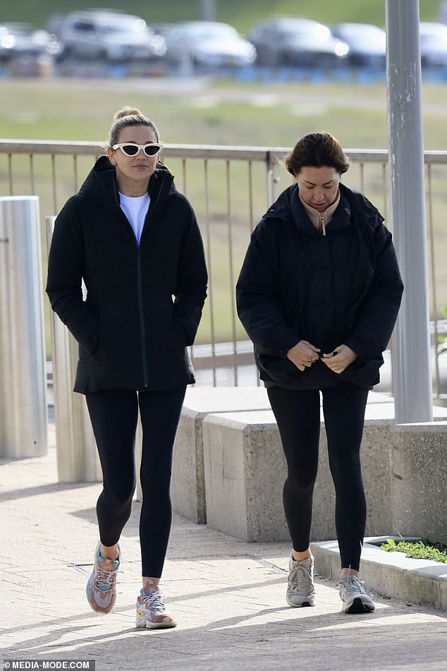 The designer went for a stroll on Bondi Beach with her good friend and former business partner, chicken heiress Tamie Ingham (left)