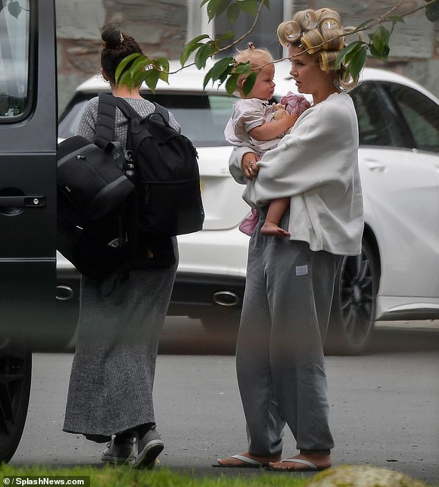 Upon arriving at the hotel, Molly wore gray sweatpants and hair rollers as she carried her 17-month-old daughter Bambi out of the car