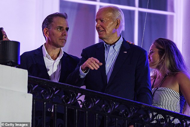 Biden talks with his son Hunter Biden after fireworks on the National Mall with First Lady Jill Biden and Vice President Kamala Harris' husband Doug Emhoff on the White House balcony