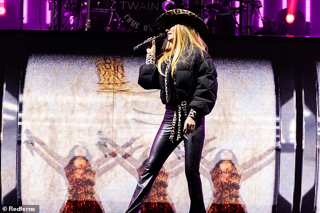 She wore another puffer jacket, this time black but with leopard print details, and teamed it with black leather pants and a leopard print cowboy hat.