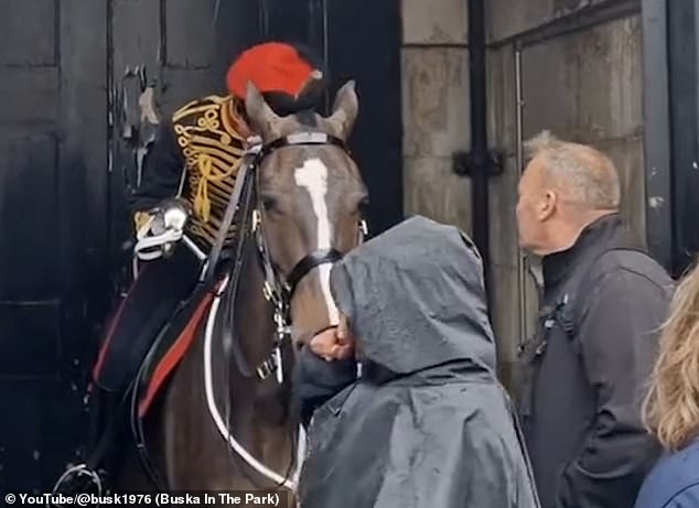 The stunned soldier wipes away her tears with her spotless white gloves as her father chats briefly with her