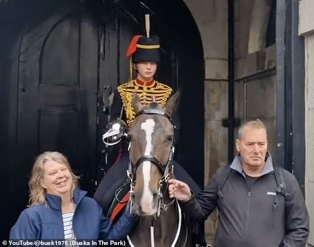 The proud parents then posed with their daughter at her guard post before the hordes of tourists came down once again to pose in the rain and pet the horse.