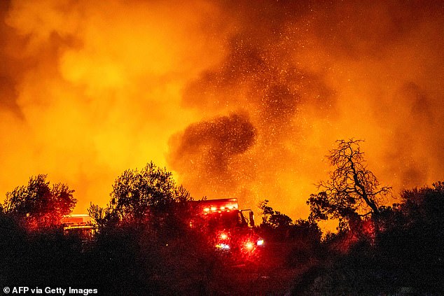 Photos from the scene show red skies and burning trees as firefighters race to get the situation under control