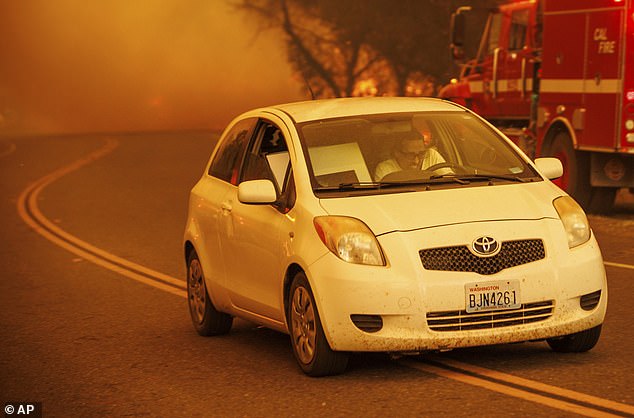 An unidentified resident, pictured above, attempting to evacuate is one of more than 28,000 people ordered to evacuate Butte County