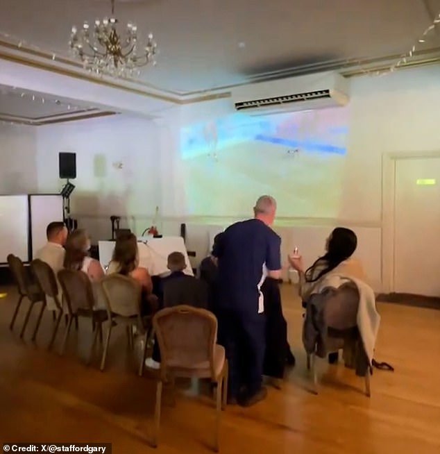 Before the panning was performed to reveal the rest of the attendees, they sat at their tables or gathered around a projector broadcasting the quarterfinals