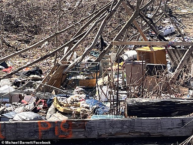 Garbage and poor housing conditions are scattered in the woods behind the street where Bach lives on in Concord