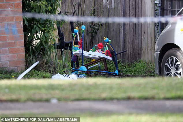 A baby walker was spotted in the front yard of the house, its colorful toys in stark contrast to the charred black house