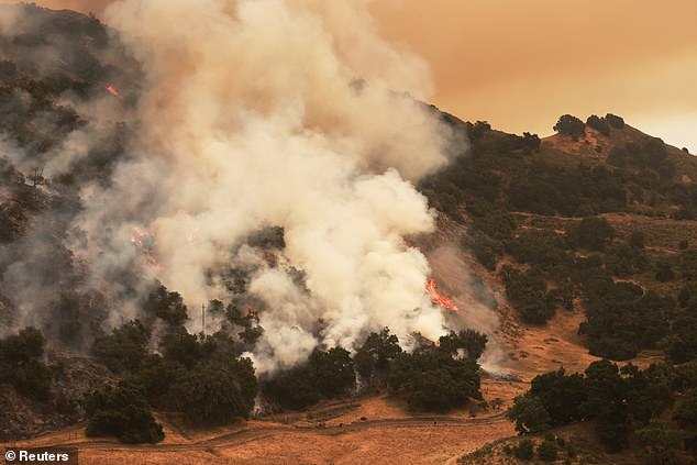 The flames and smoke have given the sky and surroundings a sepia tint