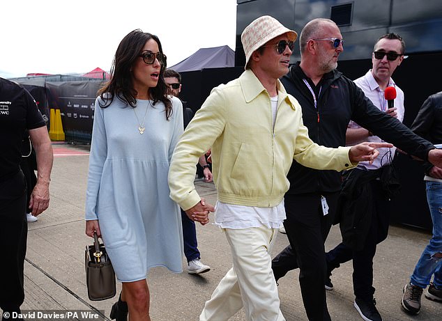 The actor, 60, looked smitten with the beauty, 34, as they turned heads while walking around the paddock