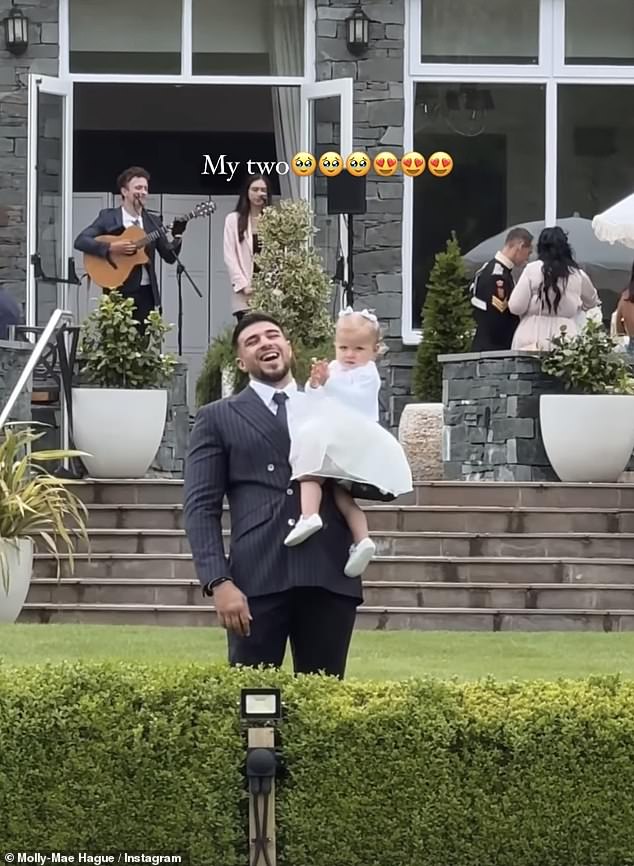 The 25-year-old influencer wore a gorgeous one-shoulder navy dress as she walked down the aisle with her daughter and flower girl Bambi, 17 months old (Tommy Fury and Bambi pictured).