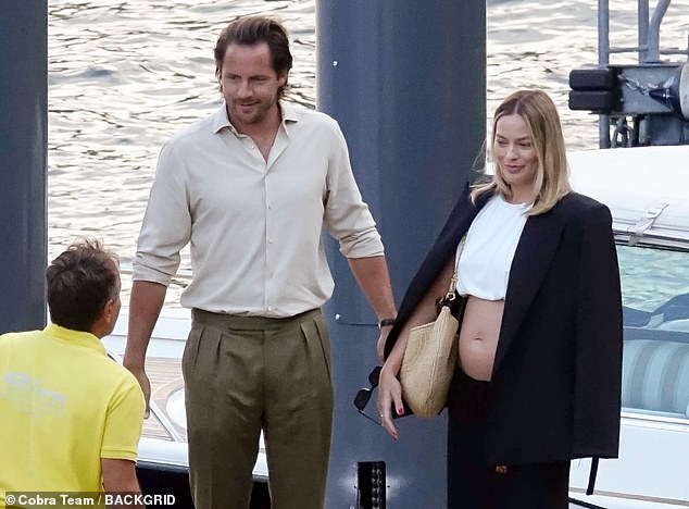 MailOnline has obtained pictures of the star proudly showing off her small but visible baby bump during the couple's holiday in Italy