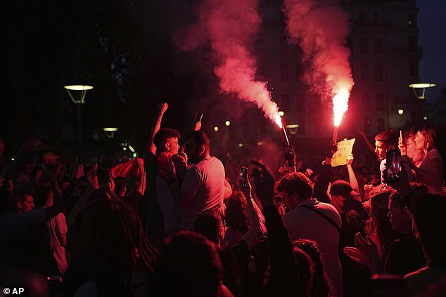 Protesters set off smoke flares in response to the expected results after the second round of parliamentary elections, in Lyon, central France, Sunday, July 7, 2024