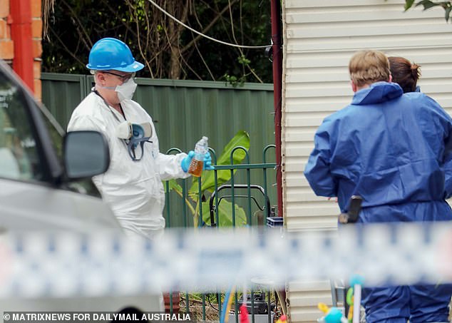 Pictured: A forensic investigator recovered a bottle of a brown, gasoline-like liquid from the scene where three children were burned alive