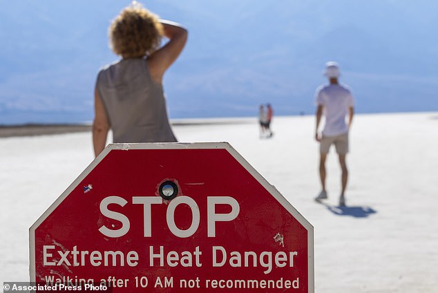 A person wipes sweat from his forehead in Badwater Basin in Death Valley National Park, where someone died Saturday