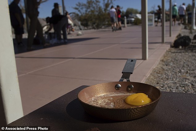 An egg sits in a small frying pan at the Furnace Creek Visitors Center in Death Valley National Park, Calif., Sunday, July 7, 2024. Weather experts predict a heat wave could break previous records across the U.S., including in Death Valley. (AP Photo/Ty ONeil)