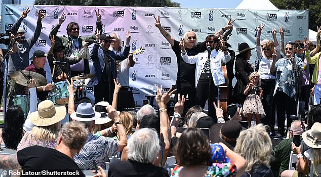 Joe was seen on stage with Ringo as he spoke to the assembled crowd, encouraging everyone to make double peace signs during the traditional 'Peace and Love' shout