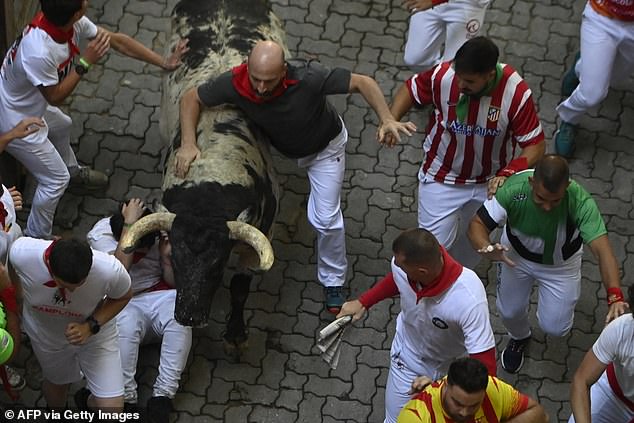 Participants run for "Beef Goat" bulls during the "turning back" (bull run) of the San Fermin festival in Pamplona, ​​​​northern Spain, on July 8, 2024