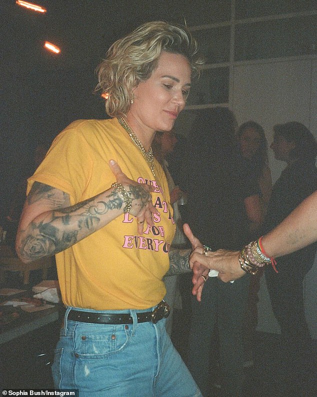 Ashlyn showed off her extensively tattooed arms in a yellow short-sleeved shirt