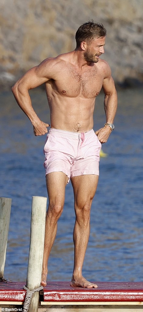 He showed off his impressive muscular body in just a pair of light-striped pink swim trunks