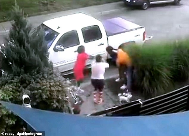 In the midst of the commotion, the child, pictured in red, reportedly points what appears to be a gun at Pippens, who is wearing the orange T-shirt