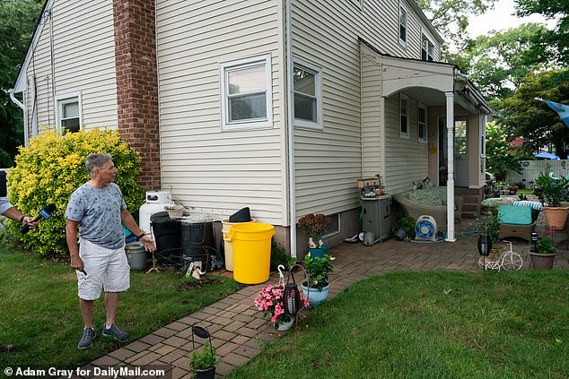 Etienne Devilliers, Rex Heuermann's neighbor, shows where Heuermann used to look over the backyard fence at his wife sunbathing in their Massapequa Park, New York, home