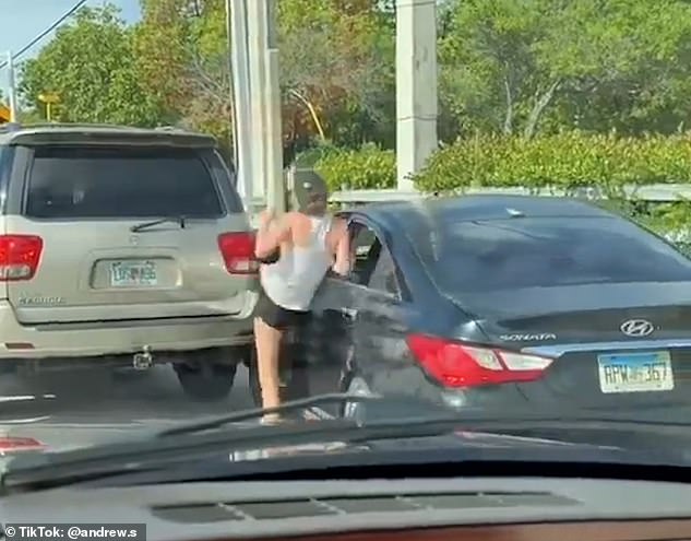 Their profanity-laden exchange escalates when the woman gets out of her car — and it appears she forgets to put on the handbrake, causing the car to crash into another parked car.