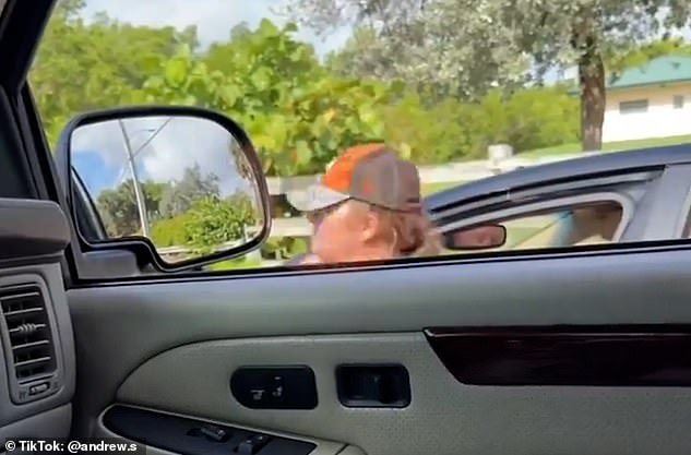 The chaotic video, which was shared on Reddit, begins with the woman sitting in the driver's seat with her door open, yelling at the male driver filming from his car a few feet away, before walking toward his car