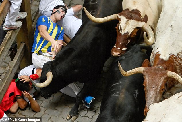 Some riders are run over by a group of bulls from the Herederos de Victoriano del Rio ranch that run through the streets during the third 'encierro' on Tuesday