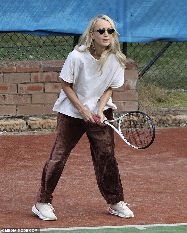 She added a pair of wide-leg, brown, crinkled velvet pants and beloved white sneakers