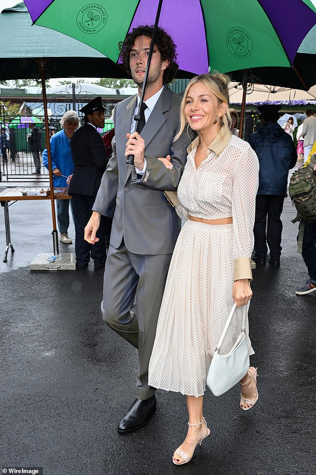 The couple arrived at the iconic location in style, as they were pictured walking arm in arm under a branded umbrella.